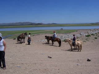 Mongolia pastoralists and horses near lake