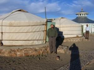 Mongolian farmer standing in front of yurt