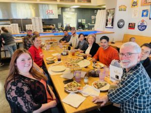 A group of people sitting around table eating lunch