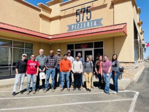 A group of people standing in front of a restaurant